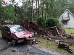 pojazd marki renault z uszkodzeniami pokolizyjnymi i uszkodzona siatka, zaś w tle dom