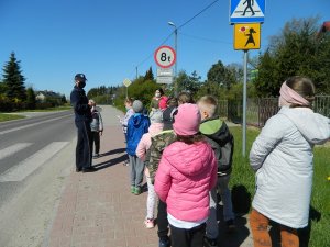 policjantka z grupą dzieci i opiekunem przy przejściu dla pieszych