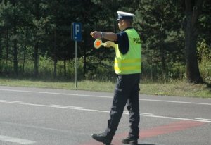 policjant stojący na drodze i kierujący ruchem