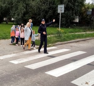 policjantka z dziećmi i opiekunem na przejściu dla pieszych