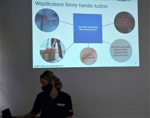 policjantka na spotkaniu w tle prezentacja z napisem współczesne formy handlu ludźmi