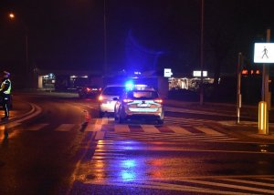 radiowóz, samochody i policjant na skrzyżowaniu