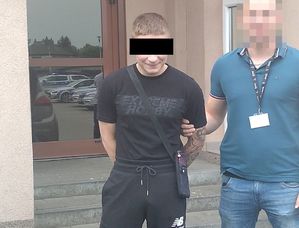 zatrzymany mężczyzna stojący z policjantem