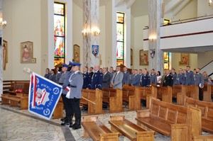 poczet komendy w kościele, w tle policjanci, pracownicy i goście