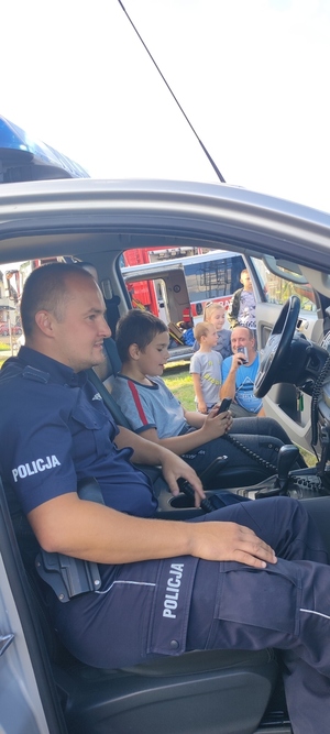 policjant z dzieckiem w radiowozie