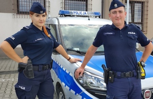 policjanci stojący przy radiowozie