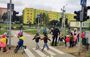 policjantka z dziećmi w miasteczku ruchu drogowego