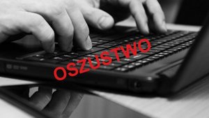 dłonie na klawiaturze laptopa, napis oszustwo