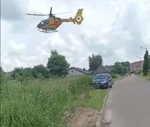 unoszący się helikopter i pojazd stojący na poboczu drogi