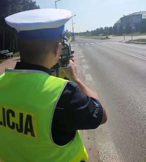 policjant ruchu drogowego mierzy prędkość pojazdów