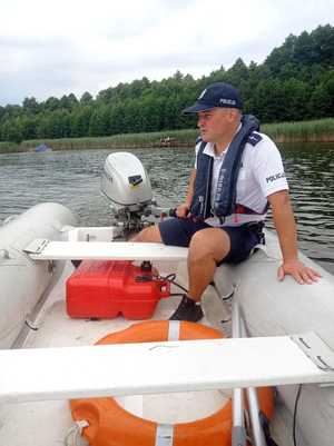 policjant na łodzi nad jeziorem