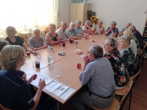 policjantki i seniorzy siedzący przy stole