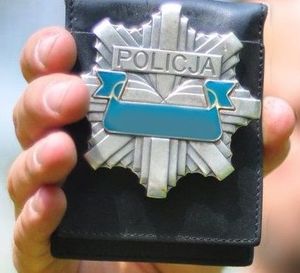 policyjna odznaka w ręku policjanta