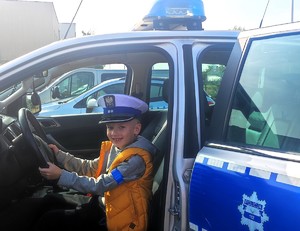 chłopiec w policyjnej czapce w radiowozie