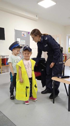 Dzieci w policyjnych czapkach i kamizelce