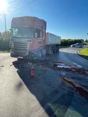 pojazd ciężarowy na drodze i rozlany płyn