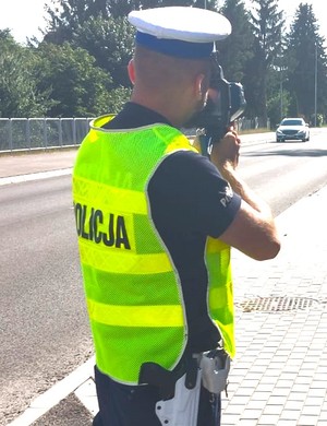 policjant podczas pomiaru prędkości na drodze