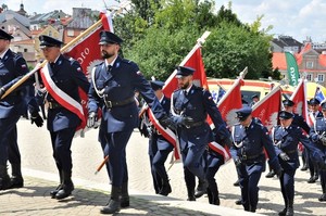 policjanci z pocztami sztandarowymi wchodzą na lubelski zamek