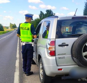 policjant z łęczyńskiej drogówki sprawdza stan trzeźwości kierujacego