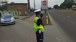 policjant pracujący z miernikiem prędkości