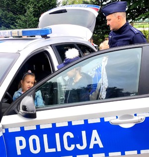 policjant z dziećmi podczas oglądania radiowozu