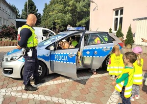 policjant prezentuje dzieciom radiowóz