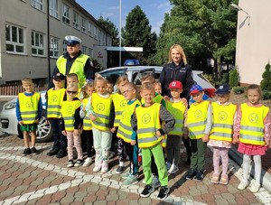 policjanci z dziećmi na tle radiowozu