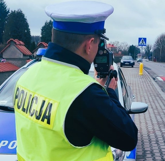 policjant mierzy prędkość pojazdów podczas działań Niechronieniu Uczestnicy Ruchu Drogowego