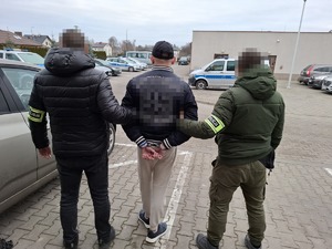 policjanci podczas doprowadzania zatrzymanego