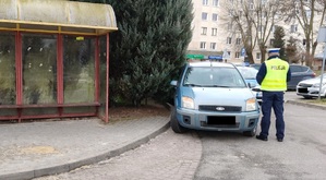 policjant przy zaparkowanym aucie