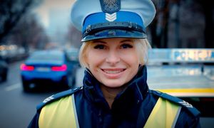 policjantka ruchu drogowego stoi przy radiowozie.