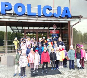 policjantka z dziećmi przed budynkiem komendy
