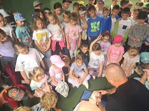 policjantka omawia udzielanie pierwszej pomocy z grupą dzieci