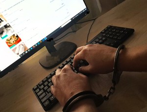 klawiatura i kajdanki założone na rękach