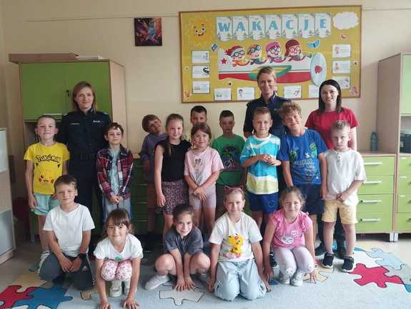 zdjęcie grupowe policjantki, nauczyciel i dzieci