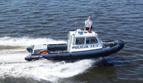 Policjanci pływają łodzią po jeziorze.