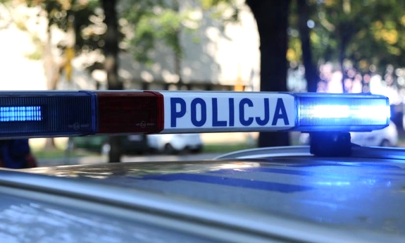 Zainstalowana na dachu radiowozu lampa z niebieskim światłem oraz podświetlanym napisem Policja