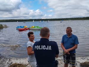policjant rozmawiający z plażowiczami