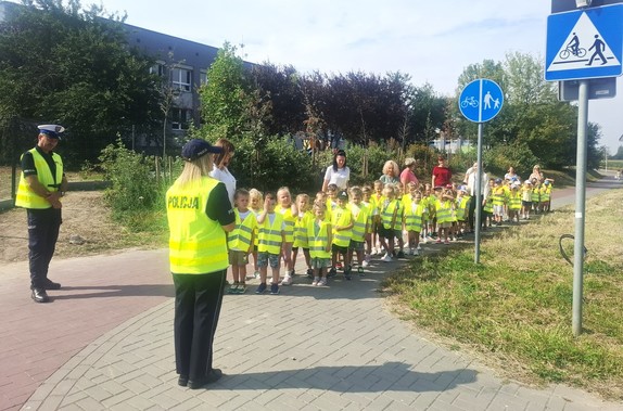 policjanci z dziećmi i opiekunami w rejonie przejścia dla pieszych