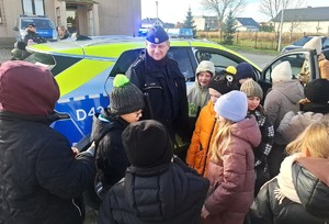 policjant z dziećmi przy radiowozie
