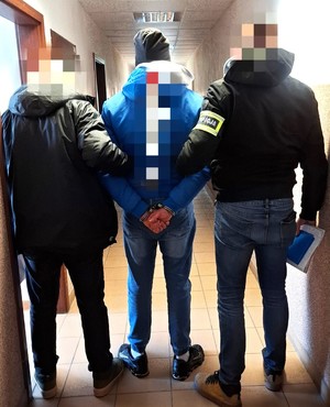 zatrzymany mężczyzna prowadzony przez policjantów