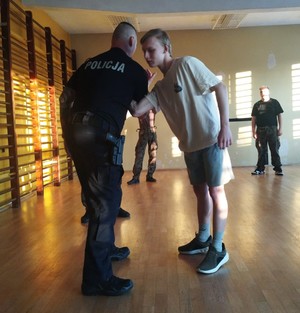policjant z uczniem podczas prezentacji taktyk interwencji