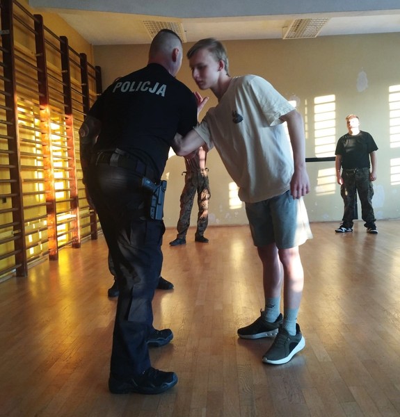policjant z uczniem podczas prezentacji taktyk interwencji