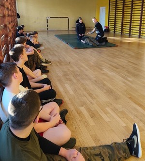 policjanci z uczniami na sali gimnastycznej