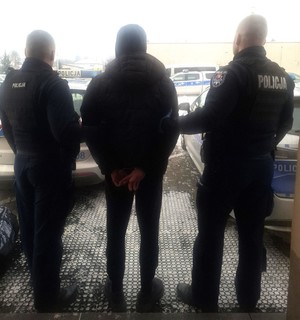 poszukiwany mężczyzna doprowadzany przez policjantów