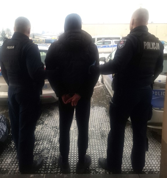 poszukiwany mężczyzna doprowadzany przez policjantów