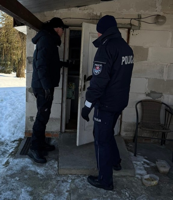 dzielnicowy i pracownik socjalny przed drzwiami