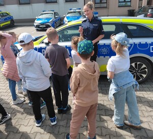 policjantka z dziećmi przy radiowozie
