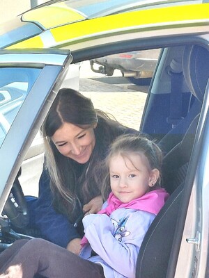 policjantka z dzieckiem w radiowozie