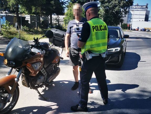 policjant podczas kontroli drogowej motocyklisty